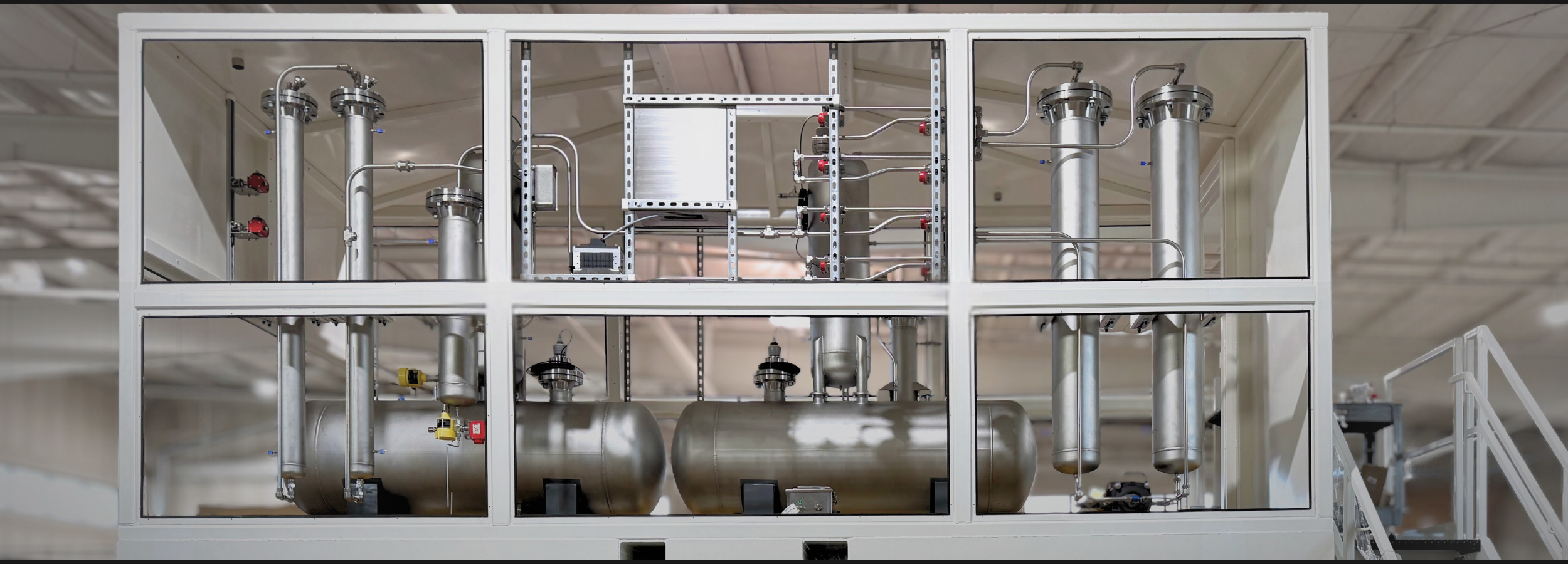 Industrial setup with metallic pipes and equipment in a room.